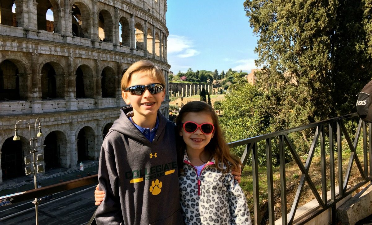 Two kids posing in front of the colossion.