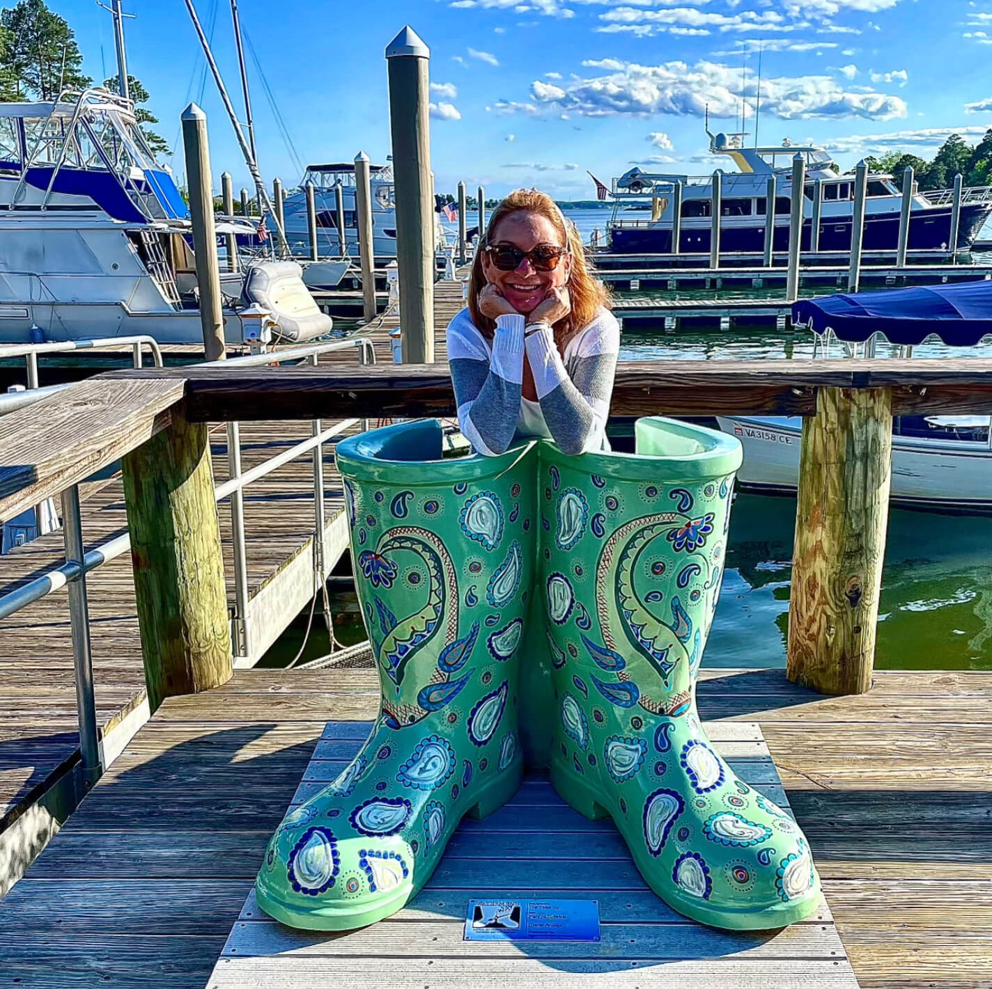 A woman posing in a bubba boots sculpture