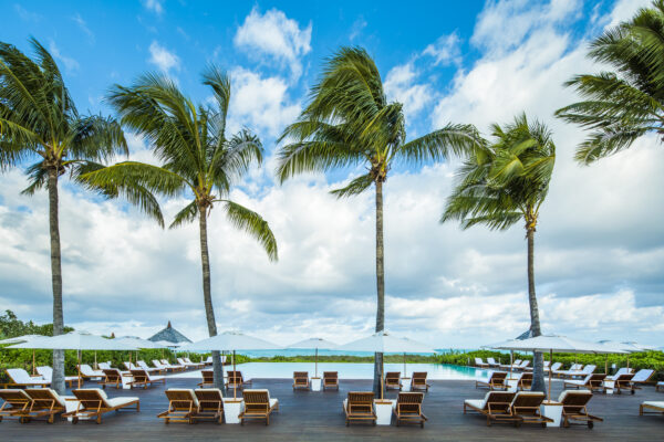 a swimming pool surrounded by pool beds and umbrellas