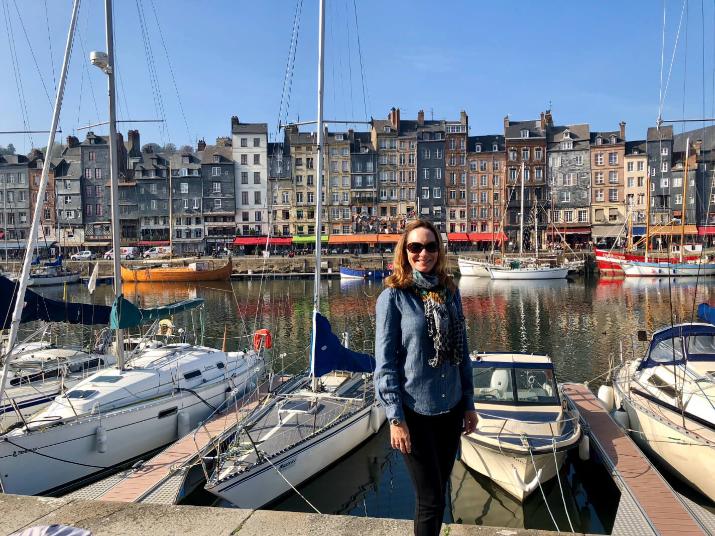 A woman with scarf standing in front of the boats