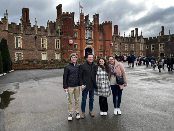 A Group of Four Standing Outside a Brick Building